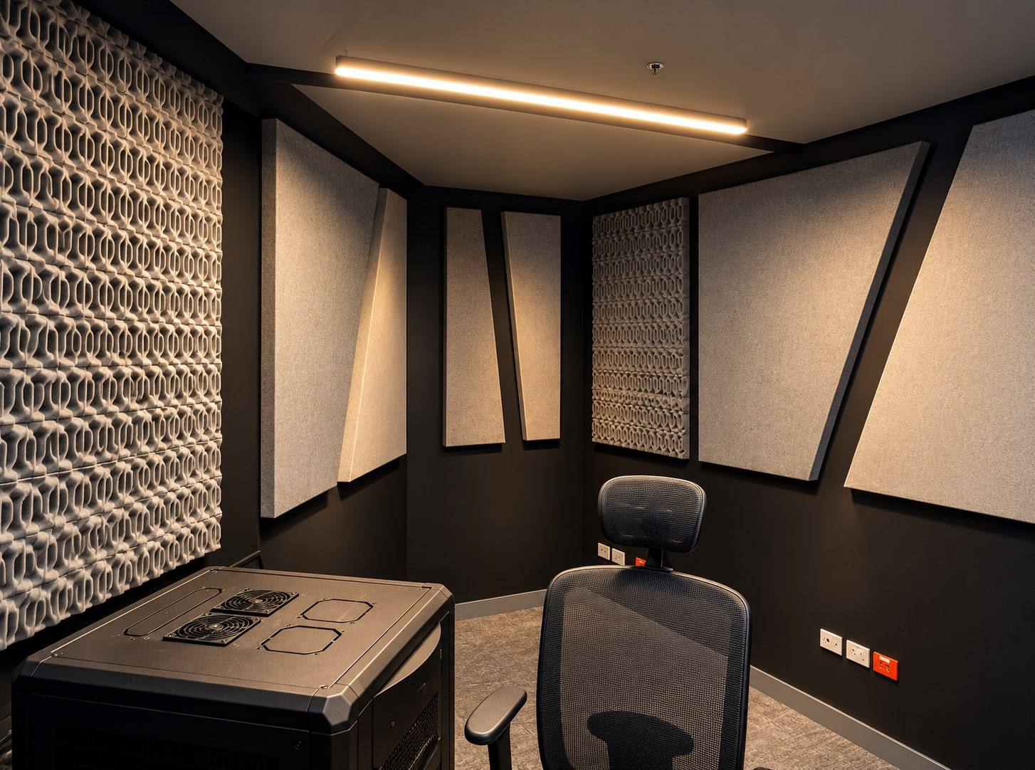 Cabina de estudio con paneles acústicos en muros y techo.