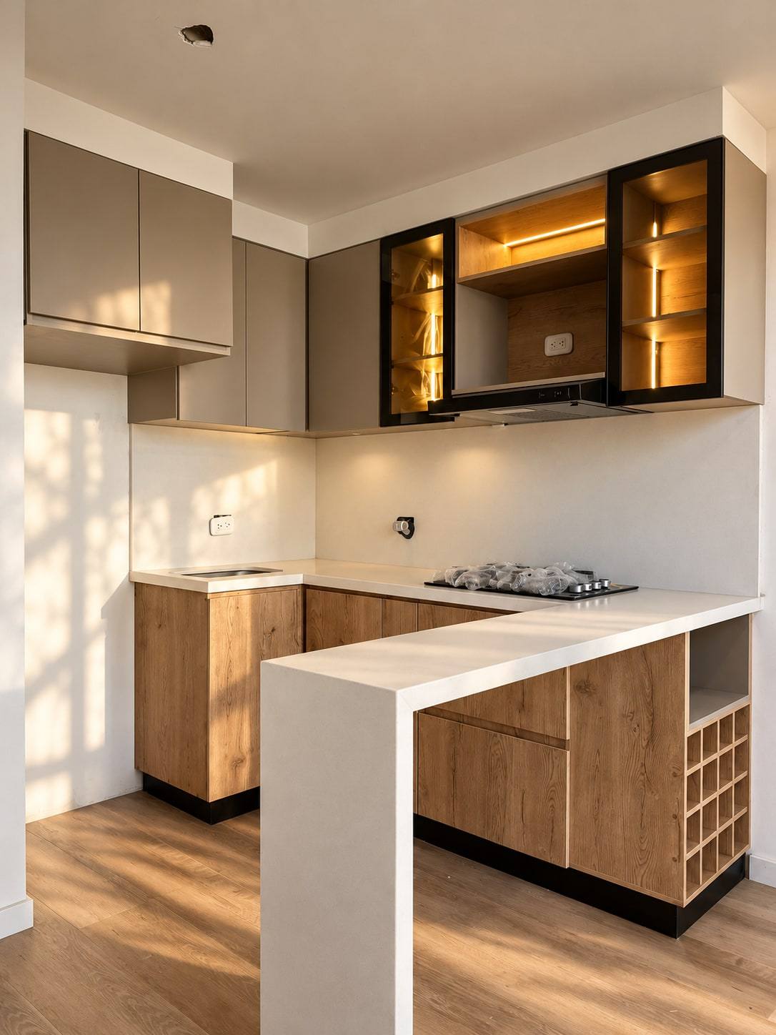 Cocina en madera y tonos claros con vitrinas iluminadas y barra.