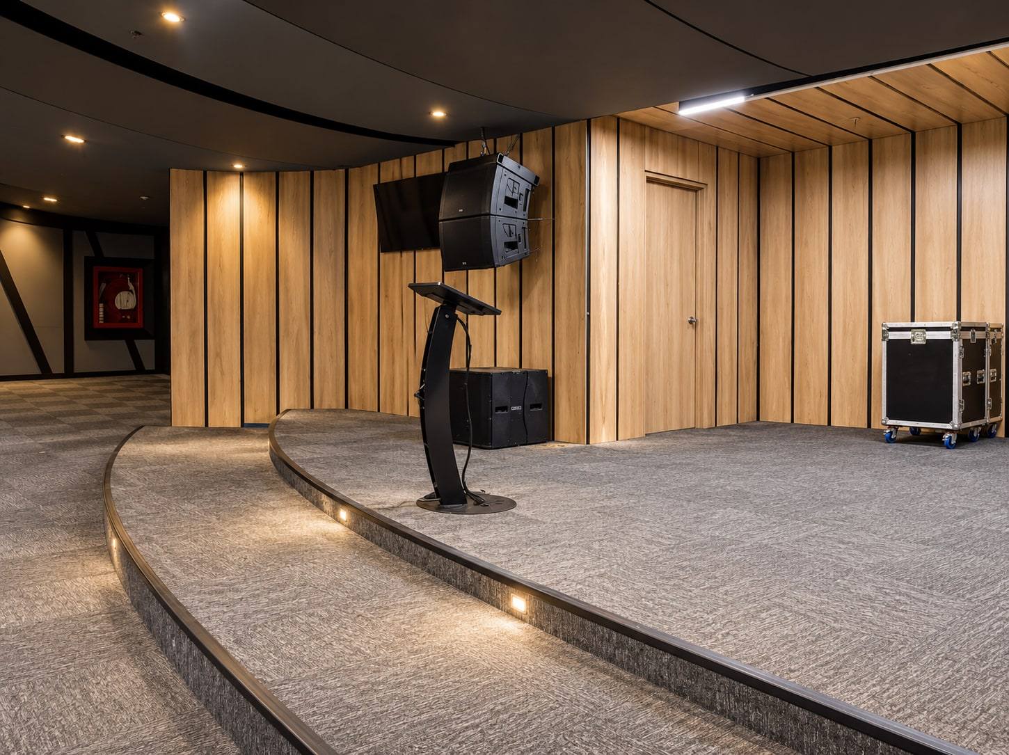 Escenario curvo con muro de listones de madera.